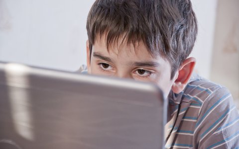 Young teen boy looking at laptop